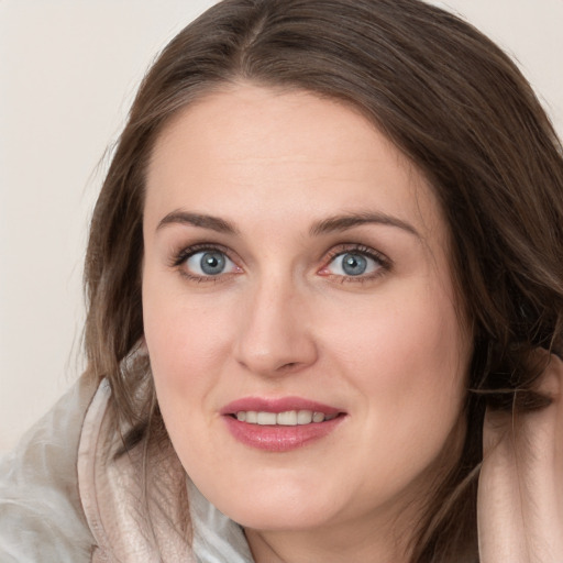 Joyful white young-adult female with medium  brown hair and blue eyes