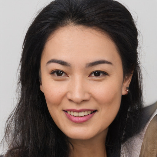 Joyful asian young-adult female with long  brown hair and brown eyes