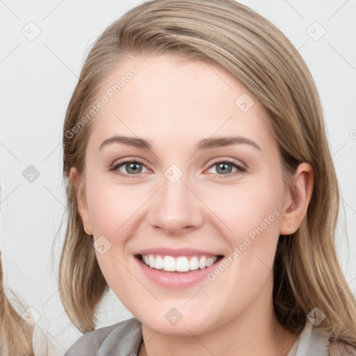 Joyful white young-adult female with long  brown hair and blue eyes