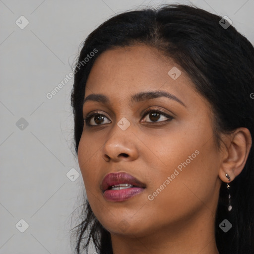 Joyful black young-adult female with long  black hair and brown eyes