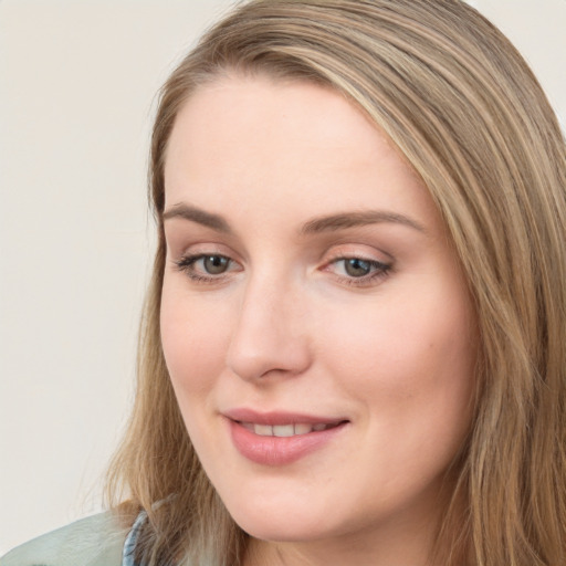 Joyful white young-adult female with long  brown hair and blue eyes