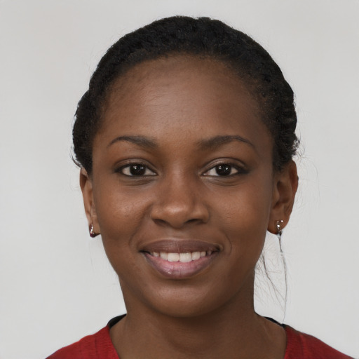 Joyful black young-adult female with long  brown hair and brown eyes