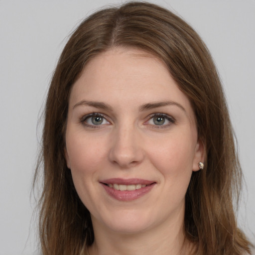 Joyful white young-adult female with long  brown hair and grey eyes