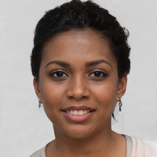 Joyful black young-adult female with short  black hair and brown eyes