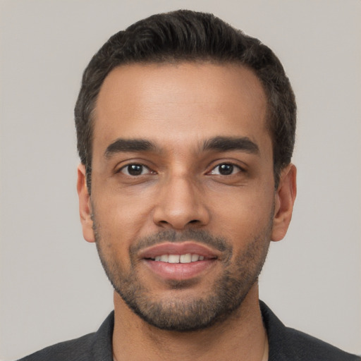 Joyful white young-adult male with short  black hair and brown eyes