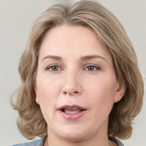 Joyful white adult female with medium  brown hair and grey eyes