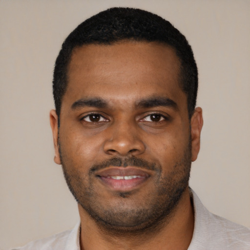 Joyful black young-adult male with short  black hair and brown eyes