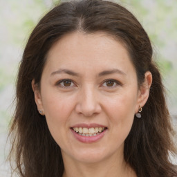 Joyful white adult female with long  brown hair and brown eyes