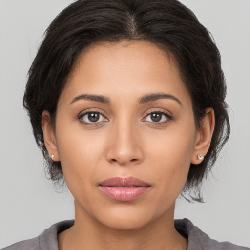 Joyful latino young-adult female with medium  brown hair and brown eyes