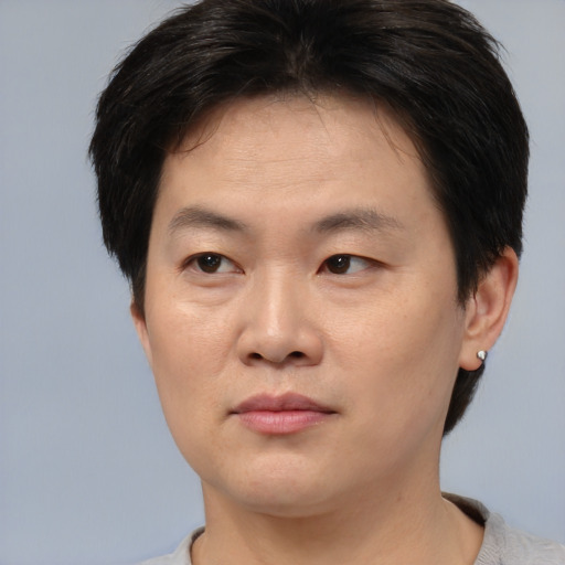 Joyful asian young-adult male with short  brown hair and brown eyes