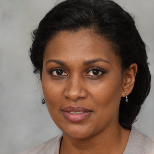 Joyful black adult female with medium  brown hair and brown eyes
