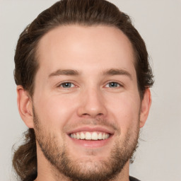 Joyful white young-adult male with short  brown hair and grey eyes