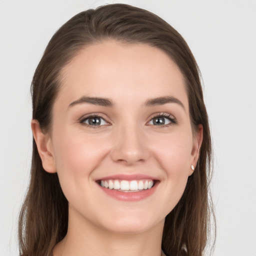 Joyful white young-adult female with long  brown hair and grey eyes