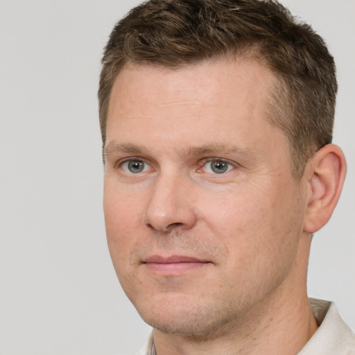 Joyful white adult male with short  brown hair and grey eyes