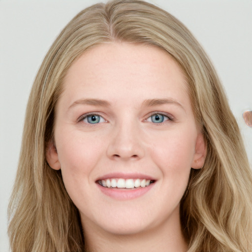 Joyful white young-adult female with long  brown hair and blue eyes