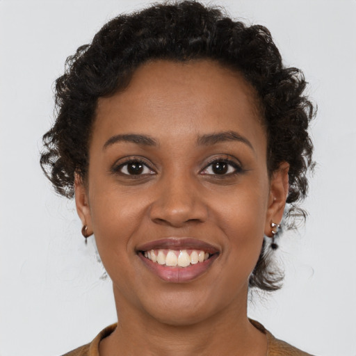 Joyful black young-adult female with short  brown hair and brown eyes