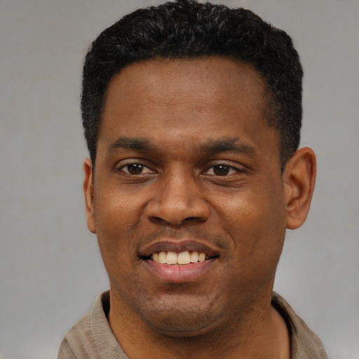 Joyful black young-adult male with short  black hair and brown eyes