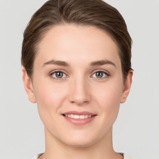 Joyful white young-adult female with short  brown hair and grey eyes