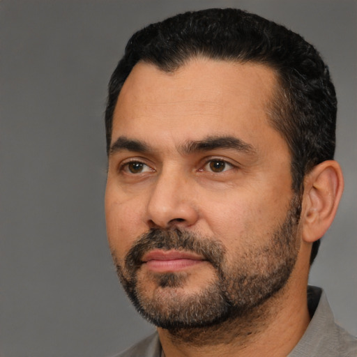 Neutral latino adult male with short  black hair and brown eyes