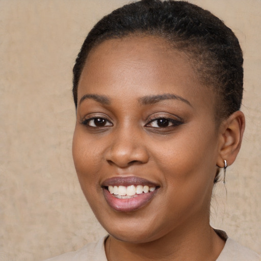 Joyful black young-adult female with short  brown hair and brown eyes