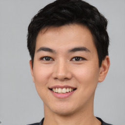 Joyful asian young-adult male with short  black hair and brown eyes