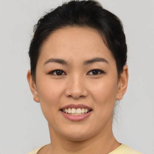 Joyful asian young-adult female with short  brown hair and brown eyes