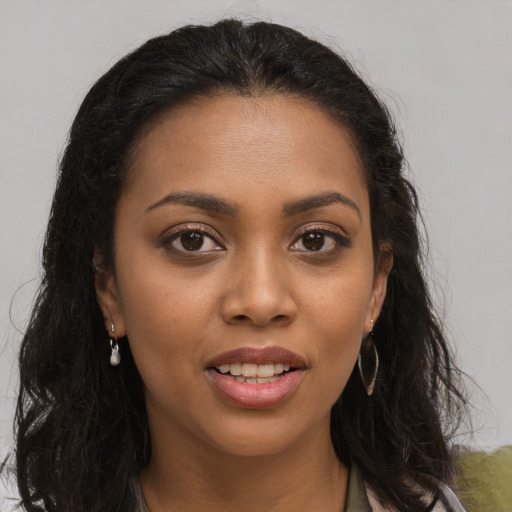 Joyful black young-adult female with long  brown hair and brown eyes