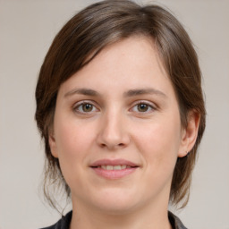 Joyful white young-adult female with medium  brown hair and grey eyes