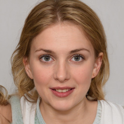 Joyful white young-adult female with medium  brown hair and blue eyes