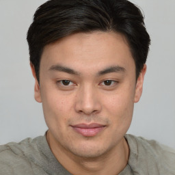 Joyful asian young-adult male with short  brown hair and brown eyes