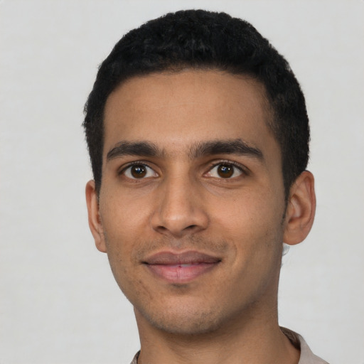 Joyful latino young-adult male with short  black hair and brown eyes