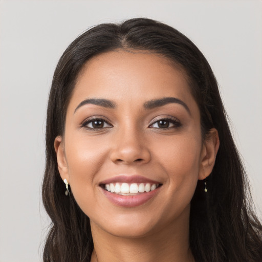 Joyful latino young-adult female with long  brown hair and brown eyes