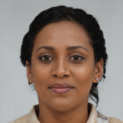 Joyful black young-adult female with short  black hair and brown eyes