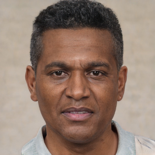 Joyful black adult male with short  black hair and brown eyes