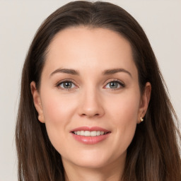 Joyful white young-adult female with long  brown hair and grey eyes