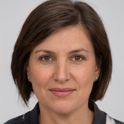 Joyful white adult female with medium  brown hair and grey eyes