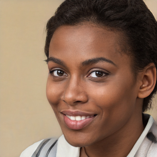 Joyful black young-adult female with short  brown hair and brown eyes