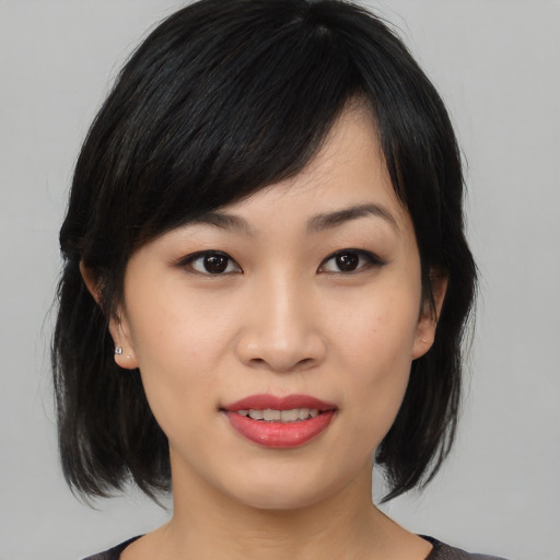 Joyful asian young-adult female with medium  black hair and brown eyes
