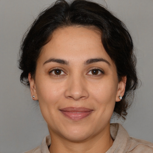 Joyful latino adult female with medium  brown hair and brown eyes