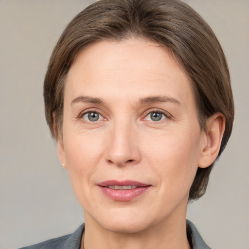 Joyful white adult female with medium  brown hair and grey eyes