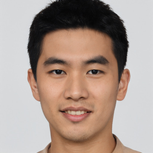 Joyful asian young-adult male with short  black hair and brown eyes