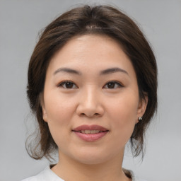 Joyful asian young-adult female with medium  brown hair and brown eyes