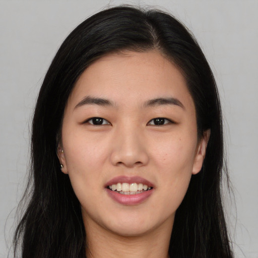 Joyful asian young-adult female with long  black hair and brown eyes