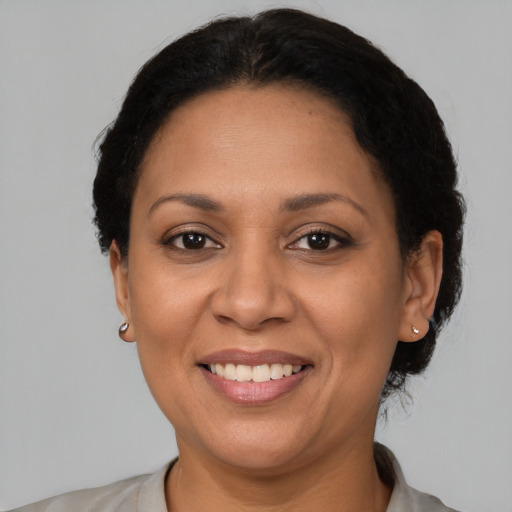 Joyful latino adult female with short  brown hair and brown eyes