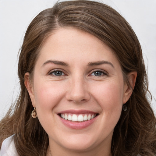 Joyful white young-adult female with long  brown hair and grey eyes