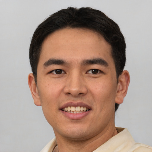 Joyful asian young-adult male with short  brown hair and brown eyes