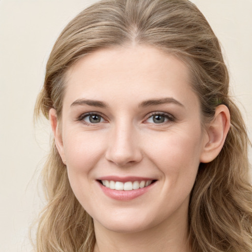 Joyful white young-adult female with long  brown hair and blue eyes