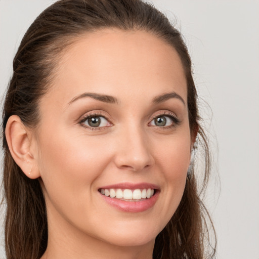 Joyful white young-adult female with long  brown hair and brown eyes