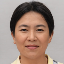 Joyful asian young-adult female with short  brown hair and brown eyes