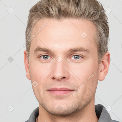 Joyful white young-adult male with short  brown hair and grey eyes